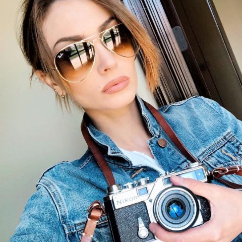 Seraina Schonenberger in a blue shirt holding a camera.