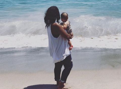 Lola Burr in the arms of her mother Nia Renee Hill at a beach.