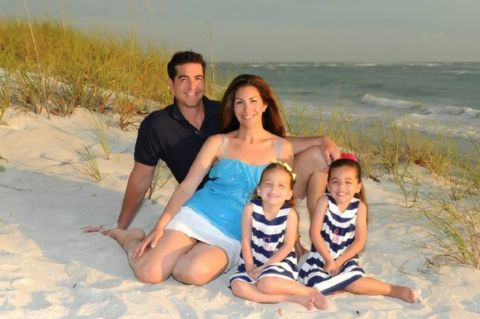 Jesse Watters in black t-shirt poses with wife Noelle Watters and their twin daughters at a beach.