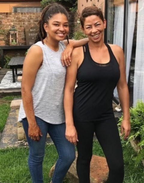 Wanda Hutchins in a black top and pant poses with her daughter.