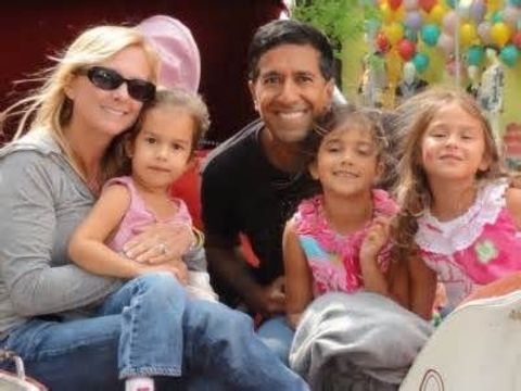 Rebecca Olson Gupta in grey poses with husband Dr.Sanjay Gupta and three daughters.