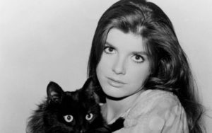 Katharine Ross poses for a picture with a black cat.