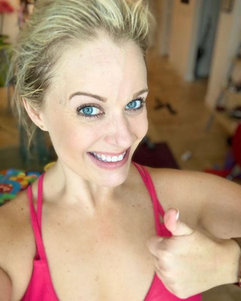 Maggie Flecknoe in a pink top poses for a selfie.