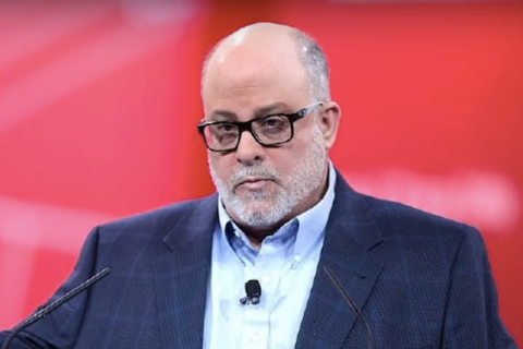 Mark Levin in a blue coat caught in the camera during an interview.