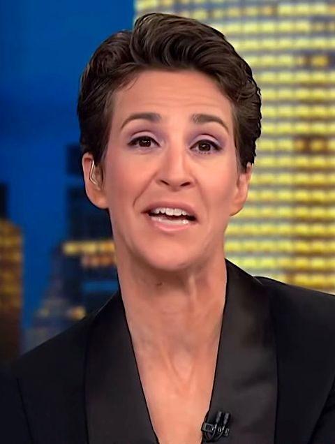 Rachel Maddow in a black suit poses for a picture.