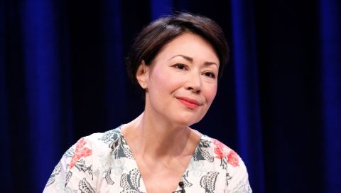 Ann Curry in a white dress poses for a picture.