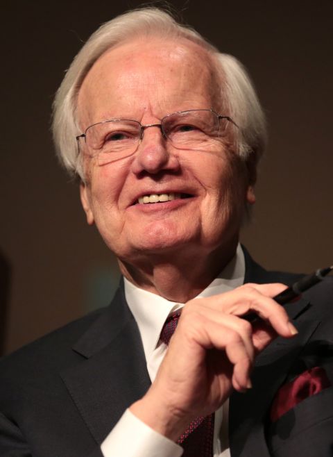 Bill Moyers caught in the camera while smiling.