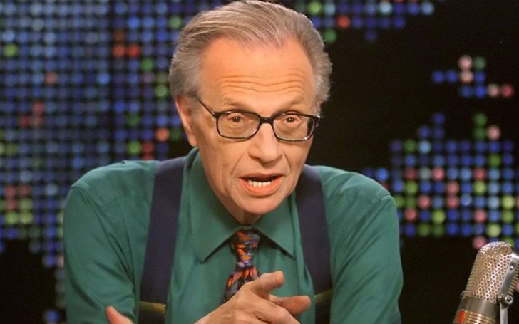 Larry King in a green shirt talking at the radio.