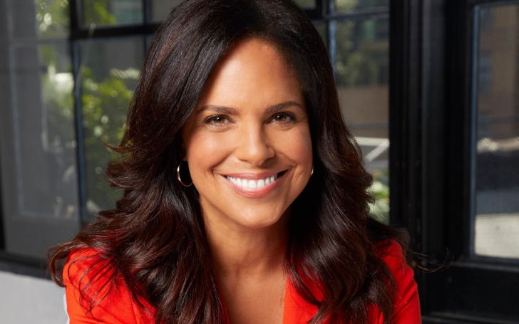 Soledad O'Brien in a red dress poses for a picture.