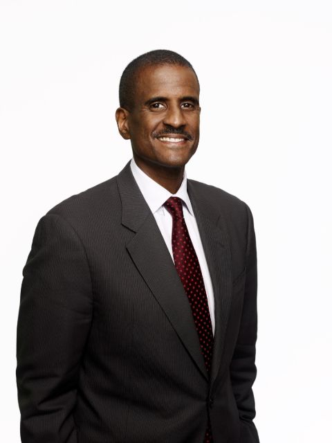 David Aldridge in a black suit poses for a picture.