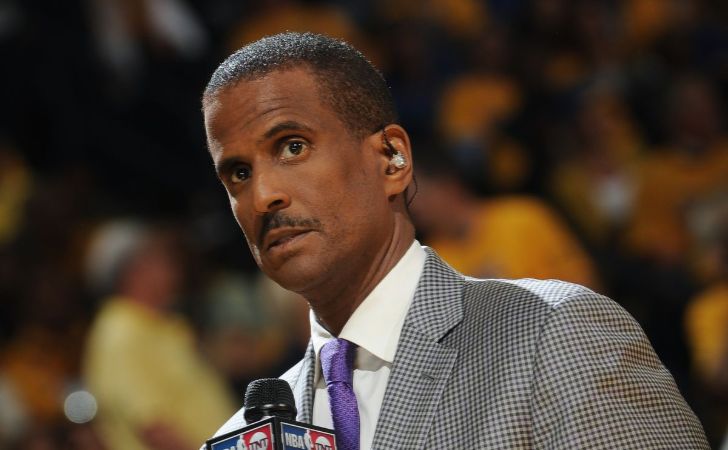 David Aldridge in a grey suit poses for a picture.