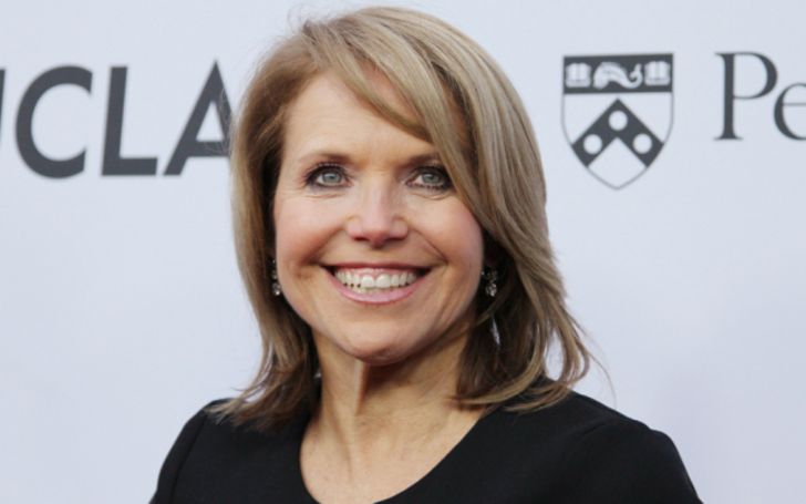 Katie Couric in a black coat poses for a picture.