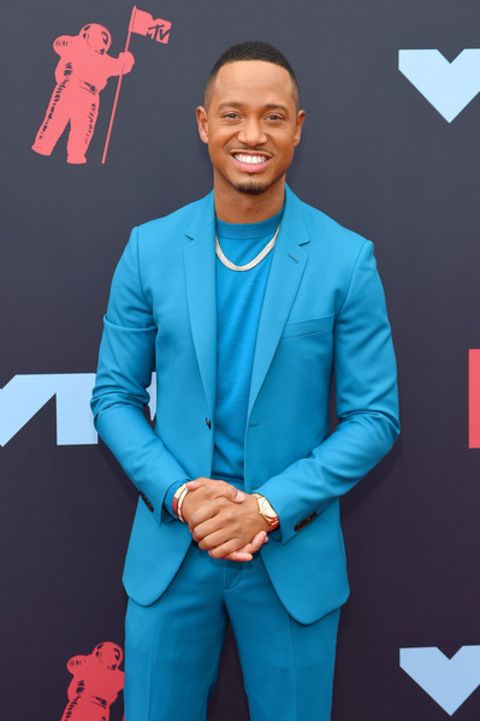 Terrence J in a blue suit poses for a picture.