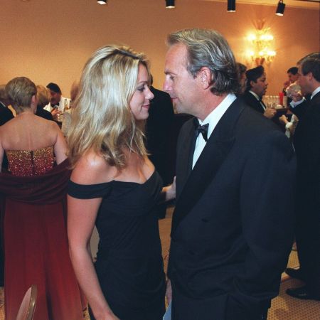 Christine Baumgartner in a black dress caught on the camera glancing at her husband Kevin Costner.