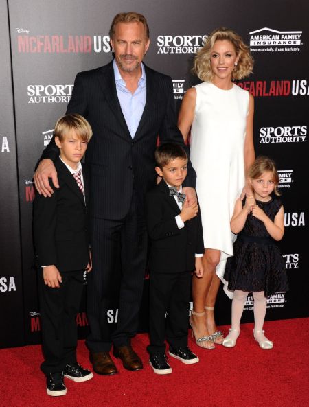 Christine Baumgartner in a white dress poses a picture with her family.